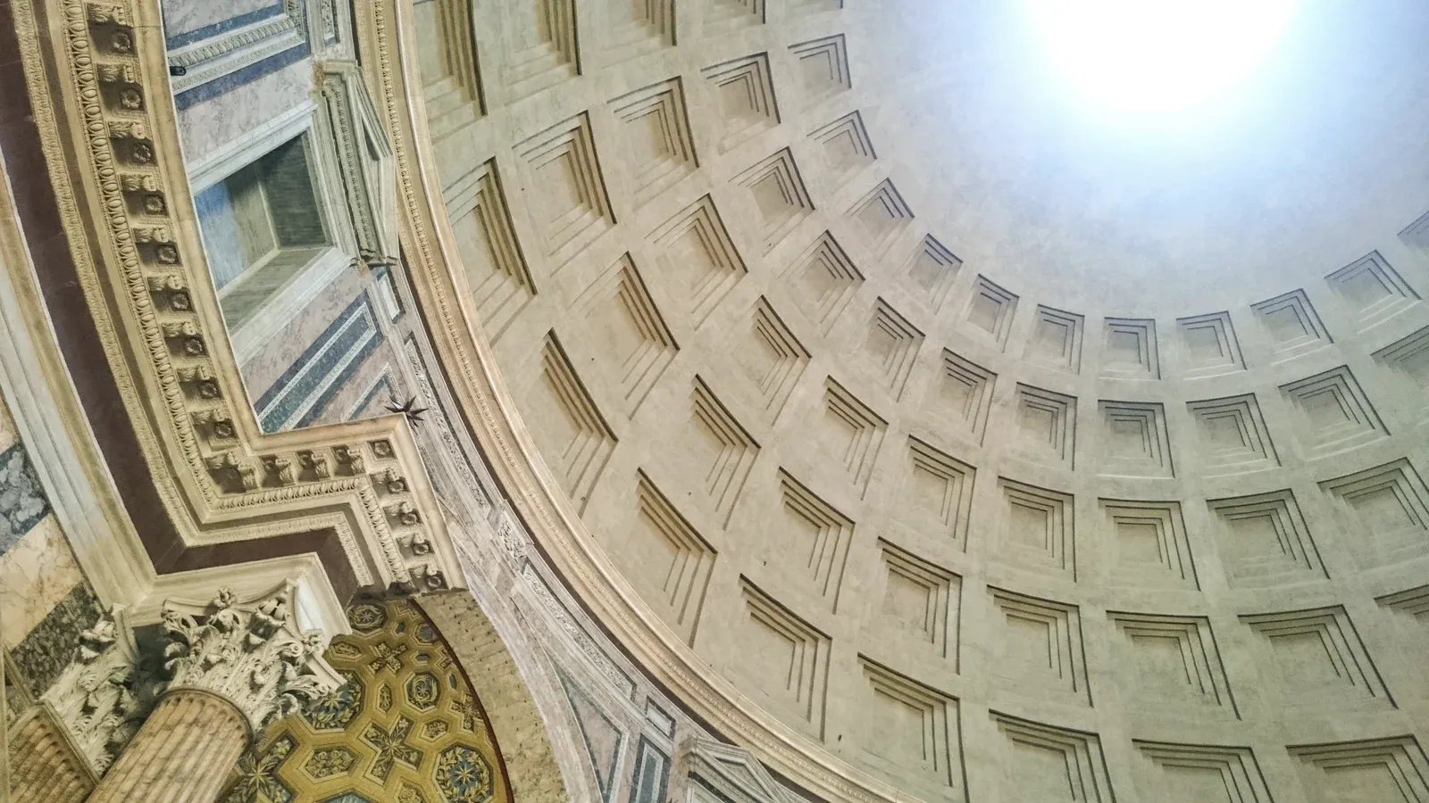 Interior of the Roman Pantheon’s concrete dome with sunlight entering through the oculus